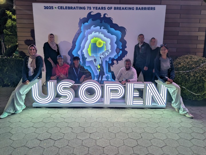 Group photo at the US Open under the lit up sign